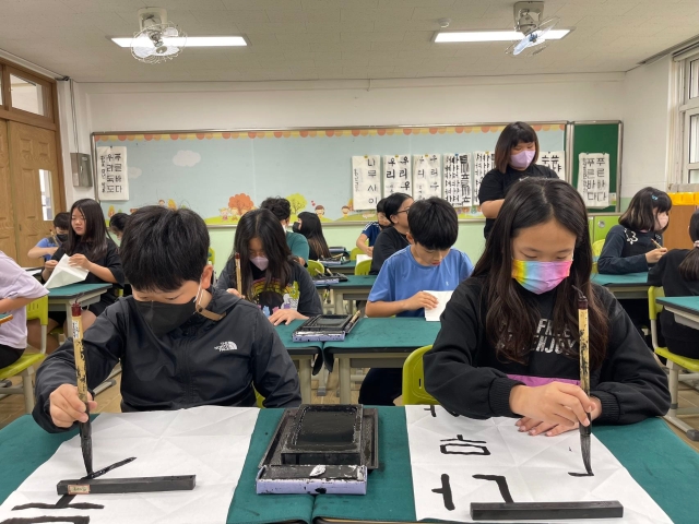 韩国学生在练习用毛笔书写。 