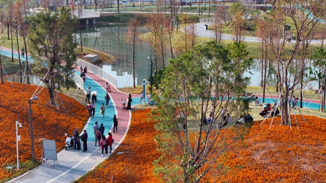 People are taking a pleasant walk and doing sports in the park. 市民在公园里惬意散步、运动。