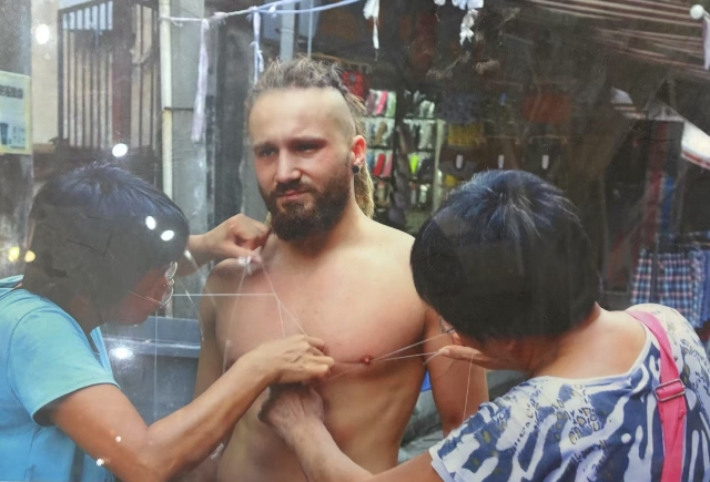 Foreigners invited into a traditional service to remove hair with threads in Guangdong in 2009, 10 yuan each time. 受访者供图