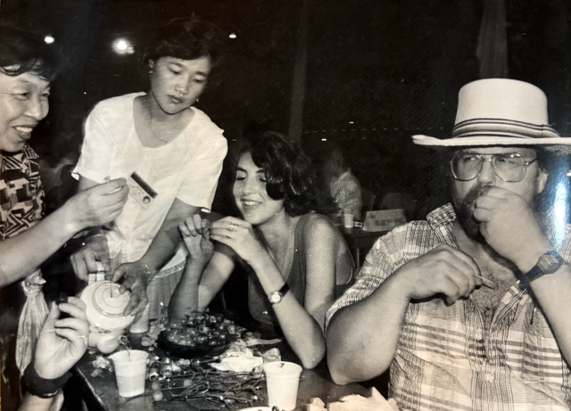 Guangzhou citizens taught foreigners how to suck fried field snails as Chinese locals did. 受访者供图