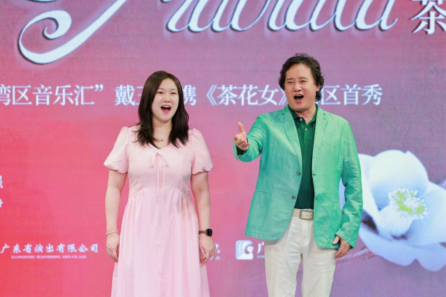 Director Dai Yuqiang perform a section with La Traviata heroine cast in the press briefing.