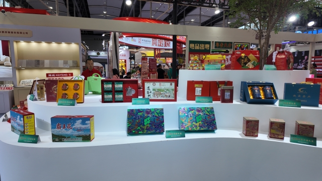 Curated display of regional specialties including Heyuan rice noodles, fermented black soybean, zongzi, etc.