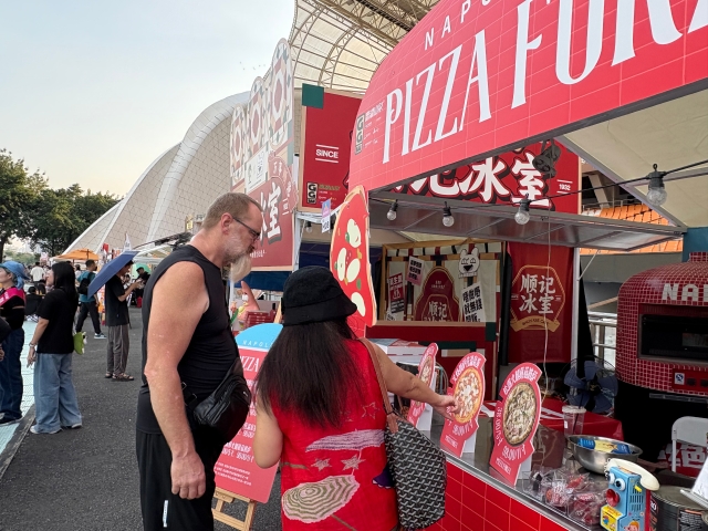 An international visitor browses the diverse food stalls at the event.