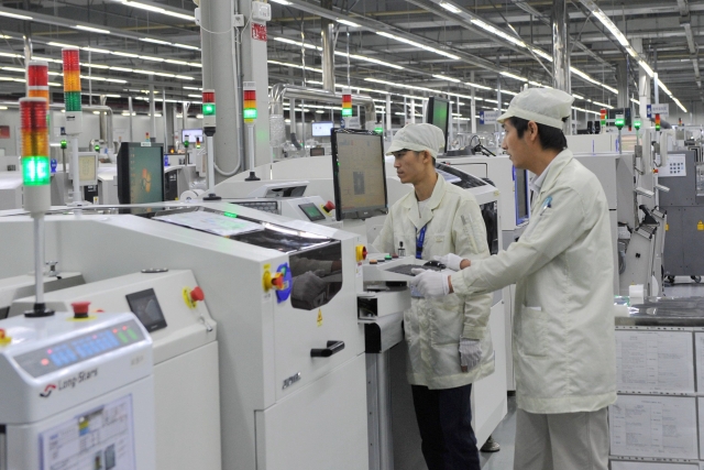 Two workers operate in the workshop of a factory in Huizhou. 南方+ 梁维春 拍摄